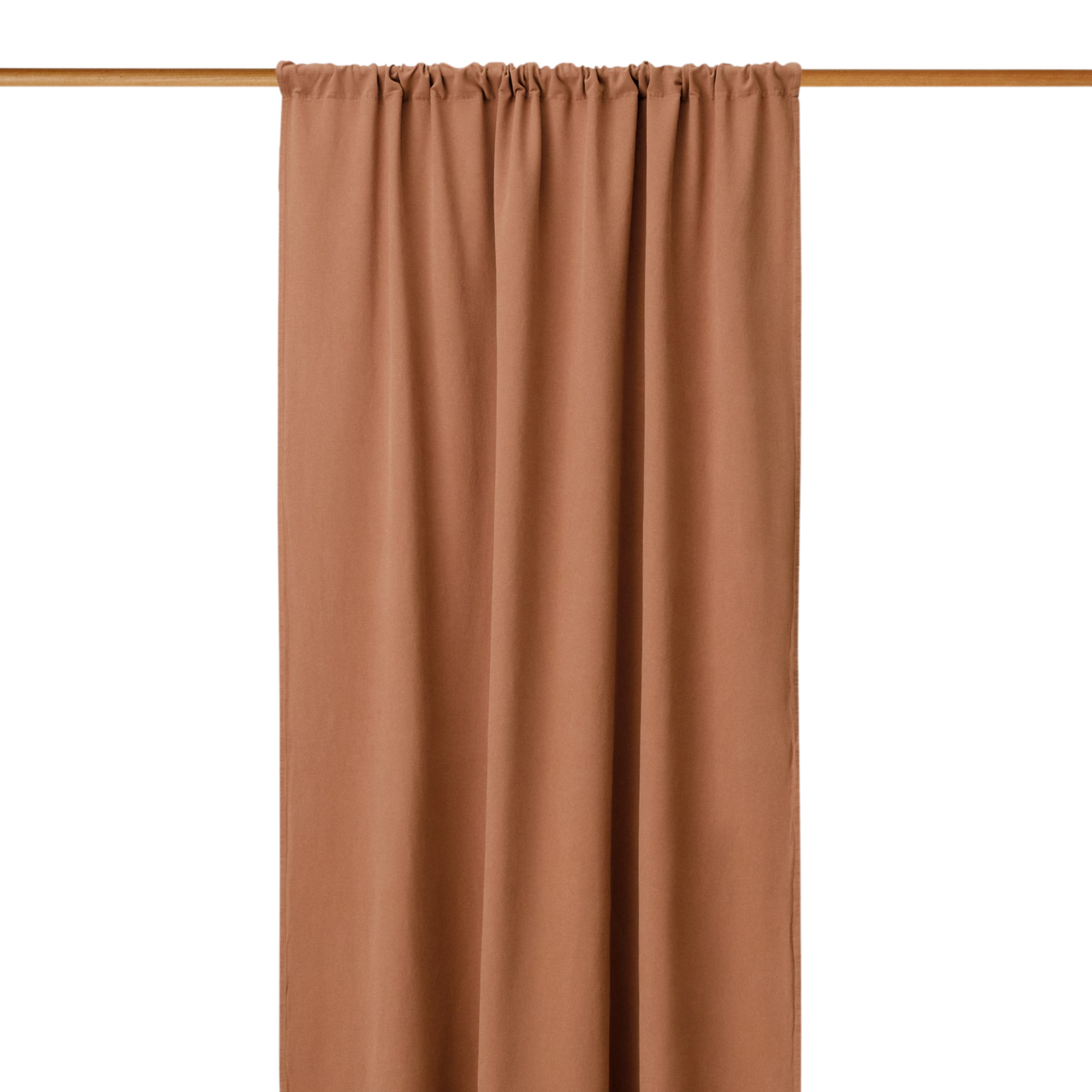 a terracotta-toned curtain hanging from a wooden rod