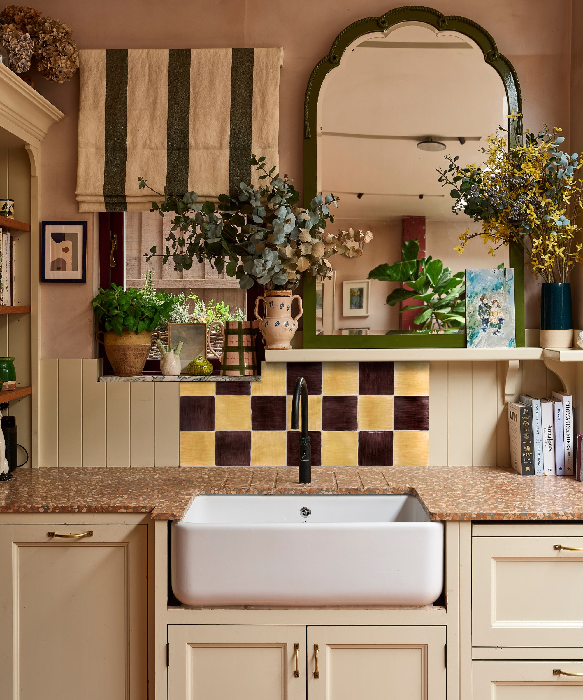 A cottage kitchen with a paneled backsplash with a square tile checkerboard backsplash behind the sink