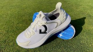 The excellent G/FORE MG4x2 Shoes resting on the green showing off their stunning white and blue colorway