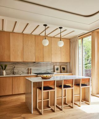 A brownstone kitchen with wooden cabinetry and a small marble island