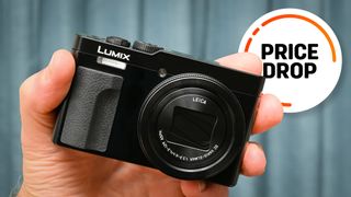 Panasonic Lumix TZ99 / ZS99 being held in hand, with the text balloon "Price Drop"