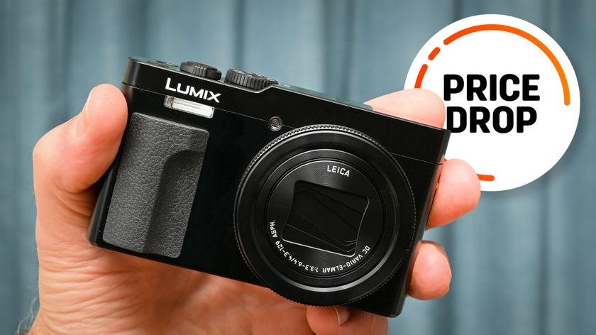 Panasonic Lumix TZ99 / ZS99 being held in hand, with the text balloon &quot;Price Drop&quot;