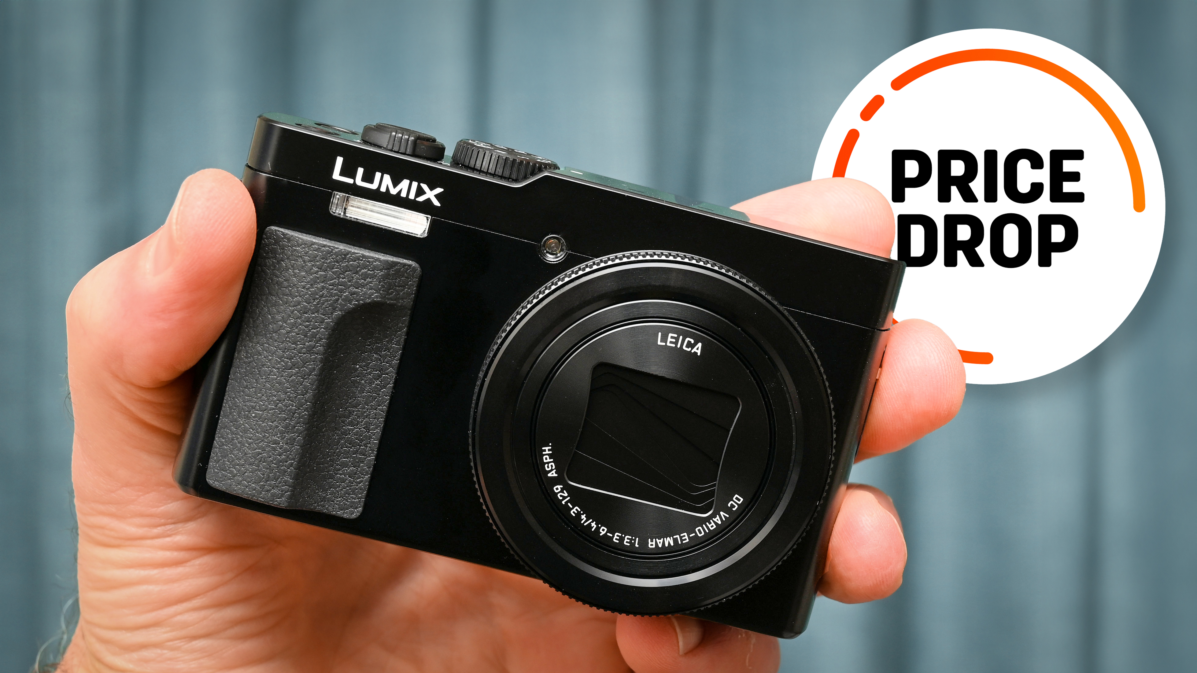 Panasonic Lumix TZ99 / ZS99 being held in hand, with the text balloon &quot;Price Drop&quot;