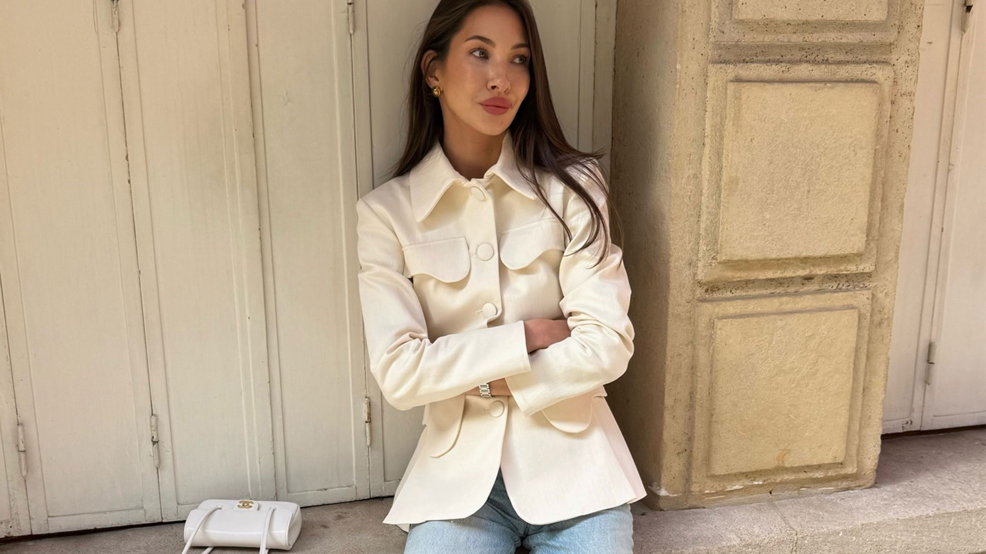 Fashion influencer wearing jeans, a white jacket, and a white Chanel bag