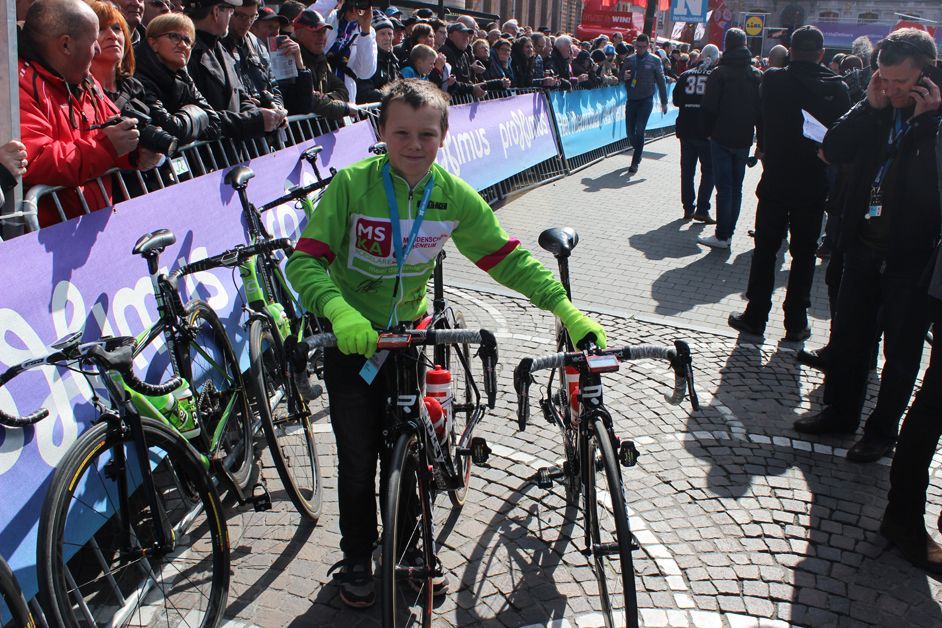 A local kid is charged with looking after Lotto Soudal's bikes while they sign on