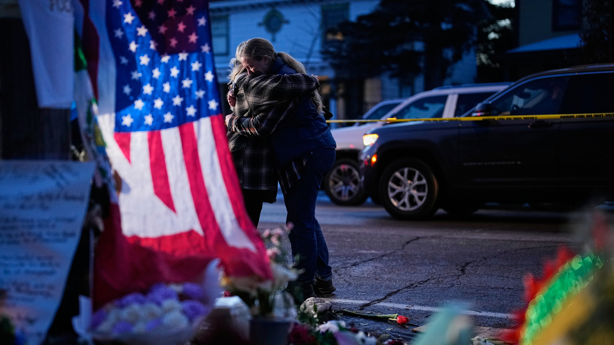 Two women embrace while visiting a memorial for Renee Good, who was fatally shot by an ICE officer last week, in Minneapolis, United States