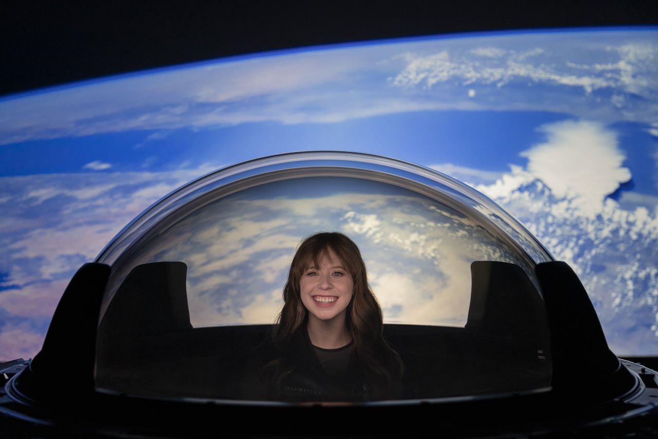 Inspiration4 astronaut Hayley Arcenaux tries out SpaceX's new cupola window for its Crew Dragon spacecraft before it was installed on the vehicle.