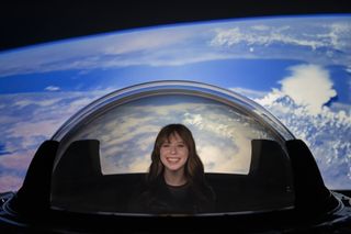 Inspiration4 astronaut Hayley Arceneaux tries out SpaceX's new cupola window for its Crew Dragon spacecraft before it was installed on the vehicle.