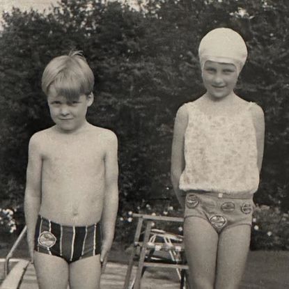 a black and white photo of Princess Diana and Earl Spencer wearing swimsuits as children