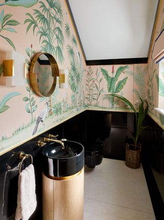 A bathroom with nature-inspired wallpaper, and black paneling