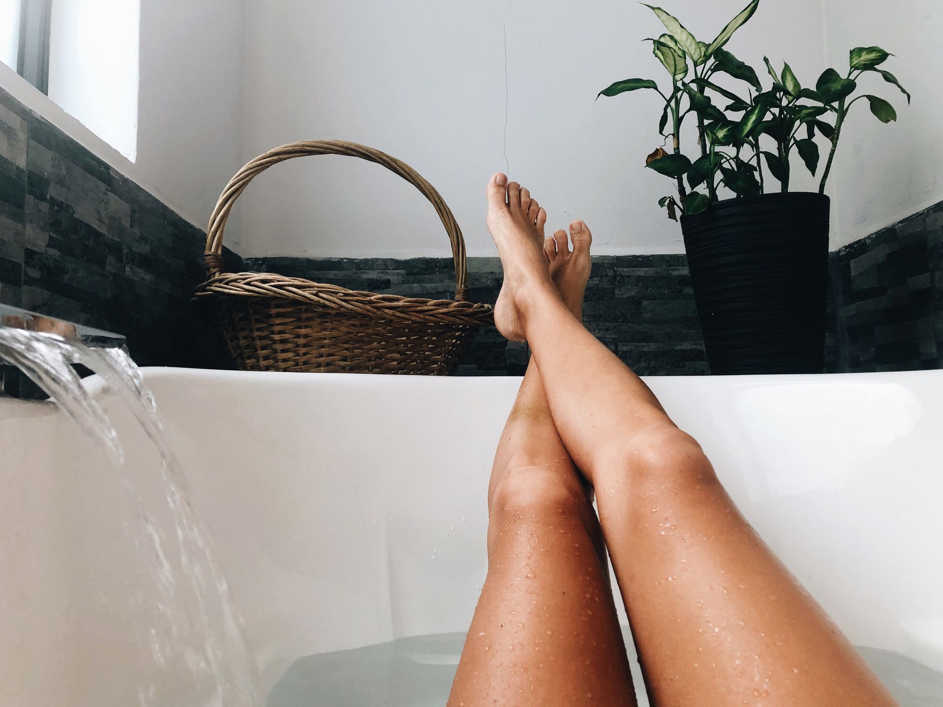 Self care ideas: Low Section Of Woman Relaxing At Home In The Bathtub