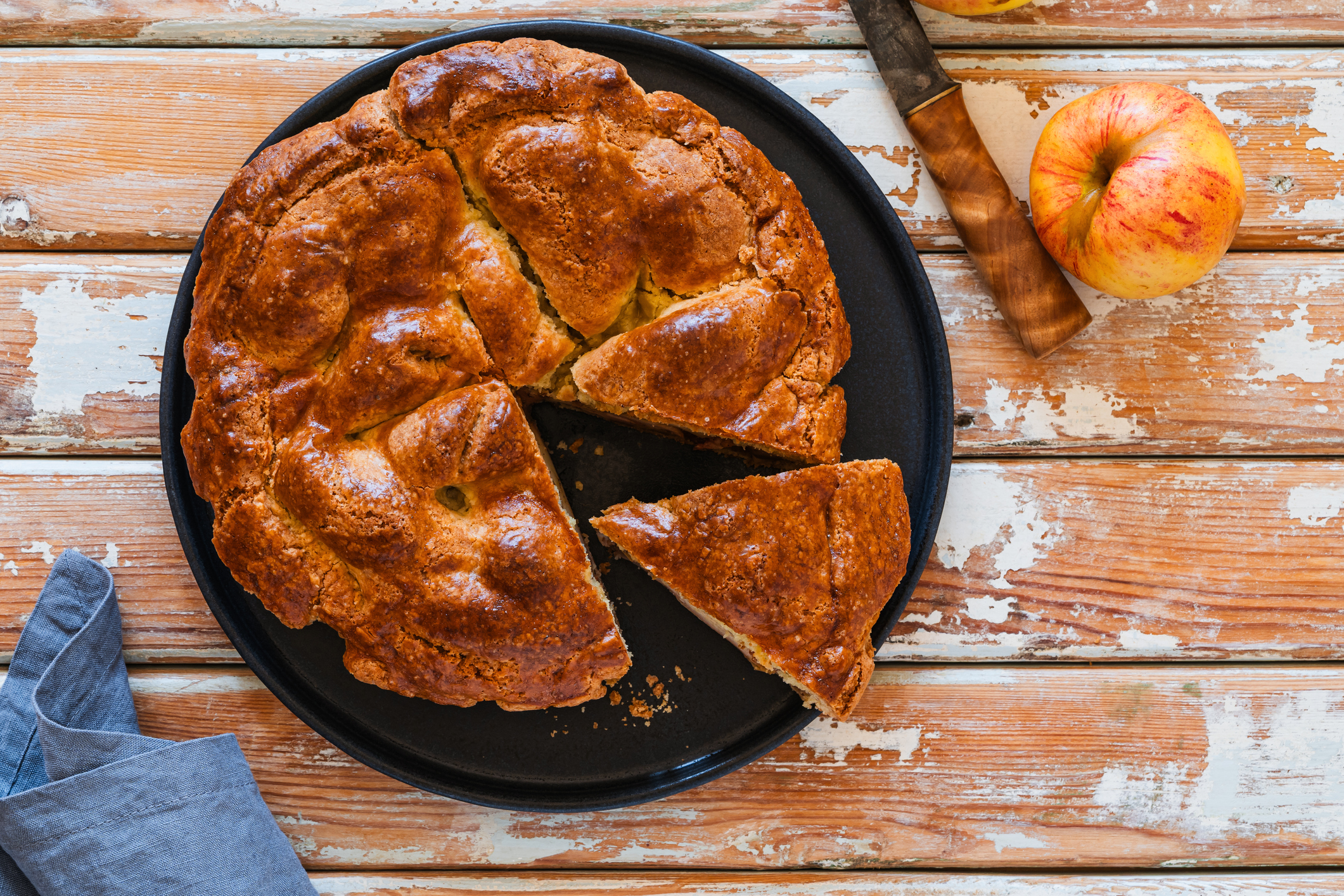 Overhead view of apple pie in plate on rural wooden table