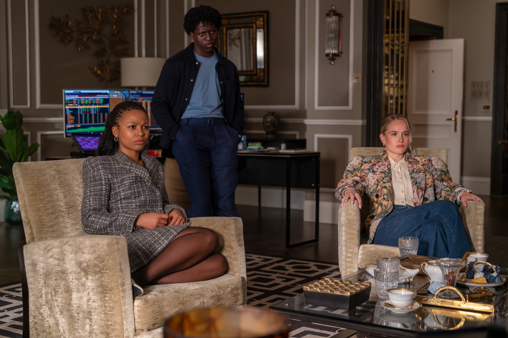 Industry Harper Stern played by Myha&amp;rsquo;la in a grey plaid blazer, black tights, white shoes sitting in a chair