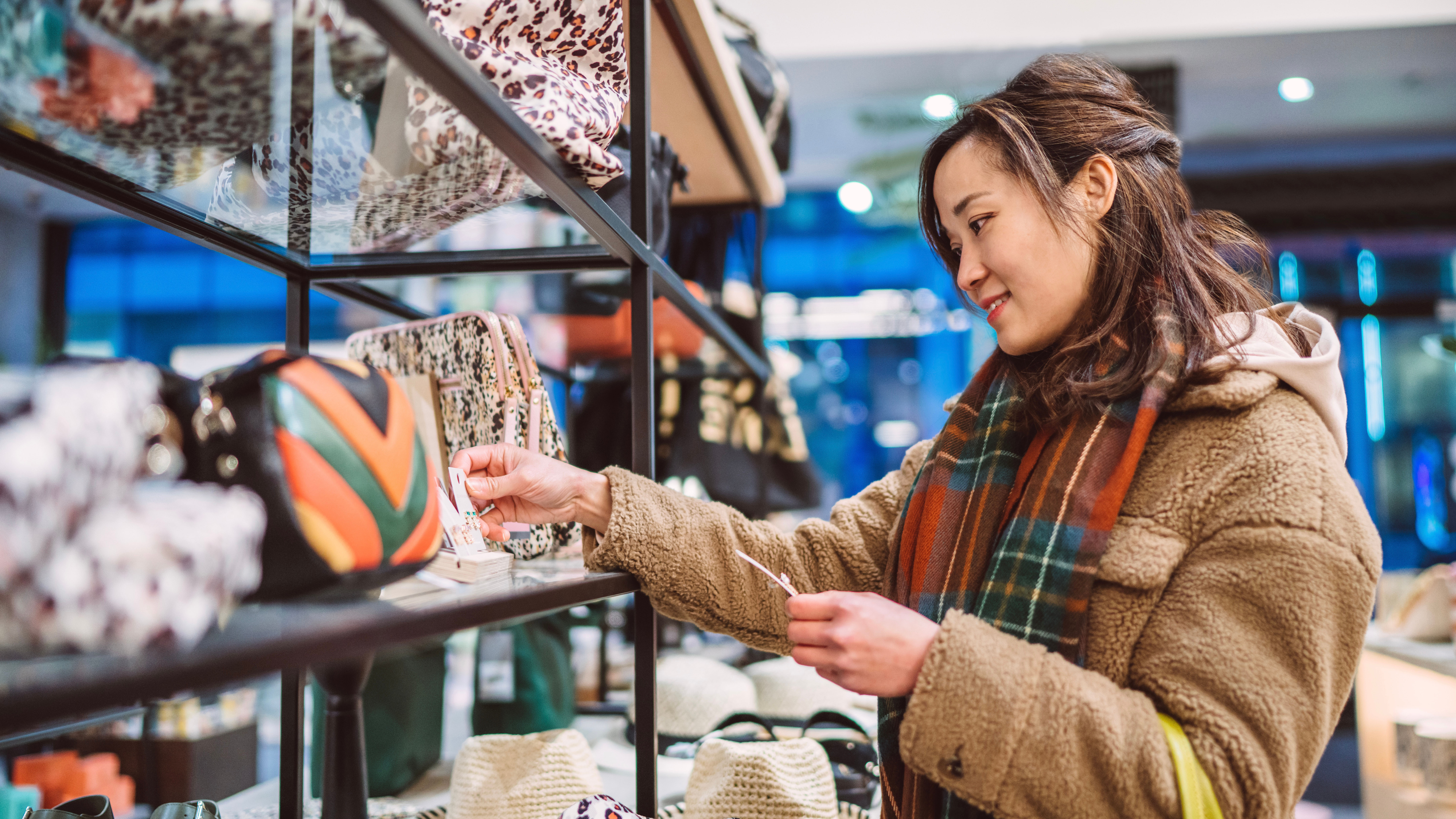 Woman checking the price tag of a bag in a shop