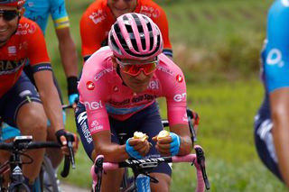 Richard Carapaz grabs a bite to eat during stage 15 at the Giro