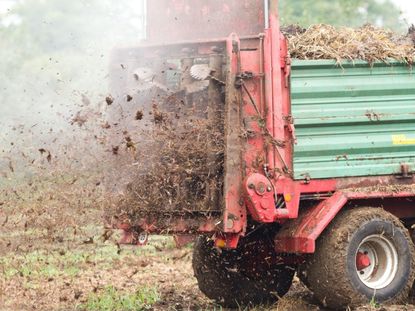A machine spreads compost on a field