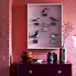 room with red wall and display textile birds