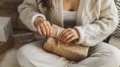 Close up of woman's hands unpacking holiday gift