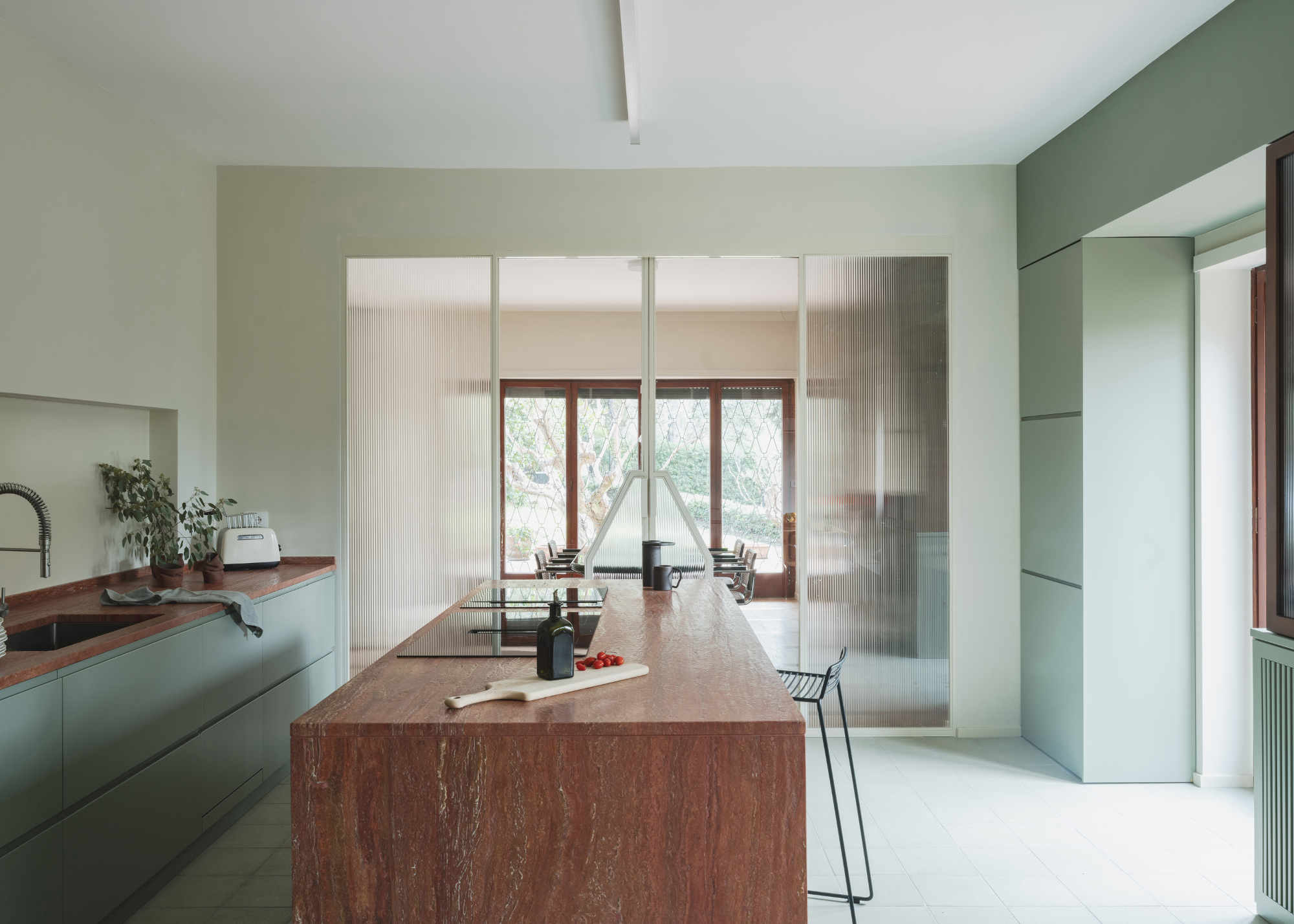 a bright airy kitchen with red travertine counters and island