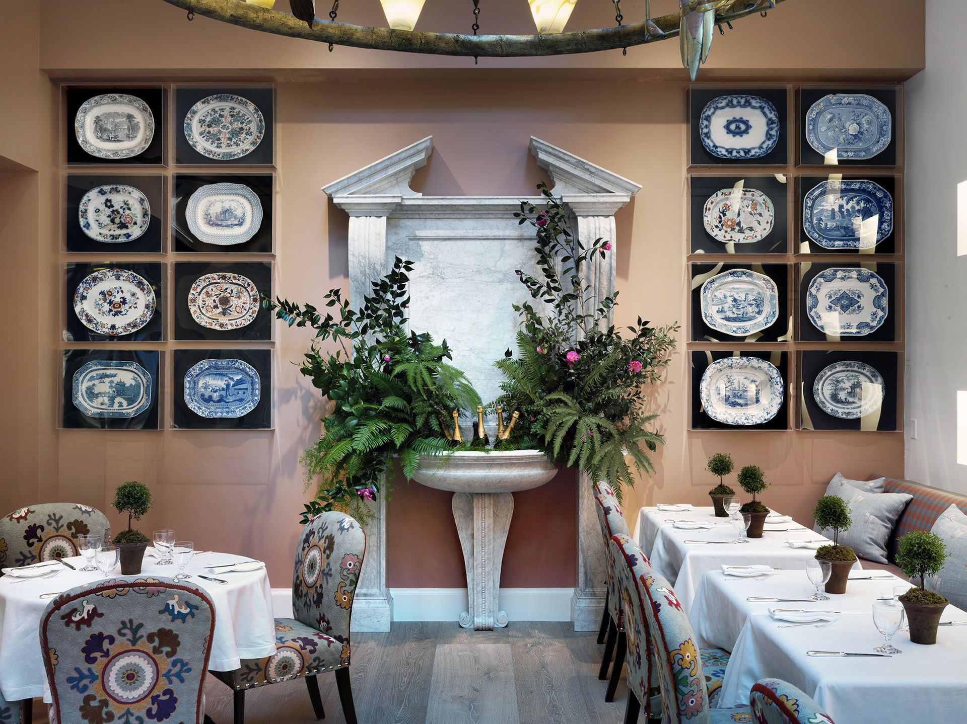 Pink dining room with plates displayed in perspex boxes
