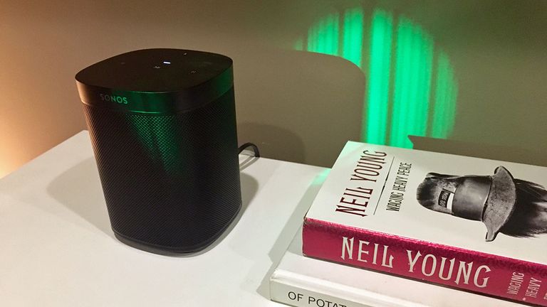 Sonos One on shelf with book