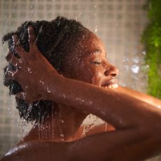 best drugstore shampoo - woman washing her hair in the shower 