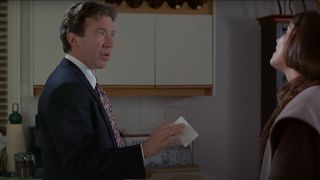 Tim Allen looks taken aback while reviewing a piece of paper in his hand in The Santa Clause.