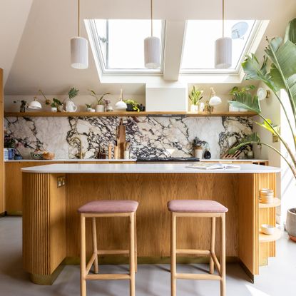 Kitchen with oak panelled island and skylights in ceiling. 