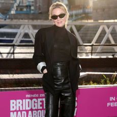 Renee Zellweger wore leather capri pants with a black blazer and black turtleneck.