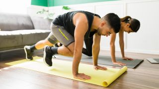 Man and woman perform the mountain climber exercise at home