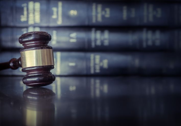 A gavel in front of books.