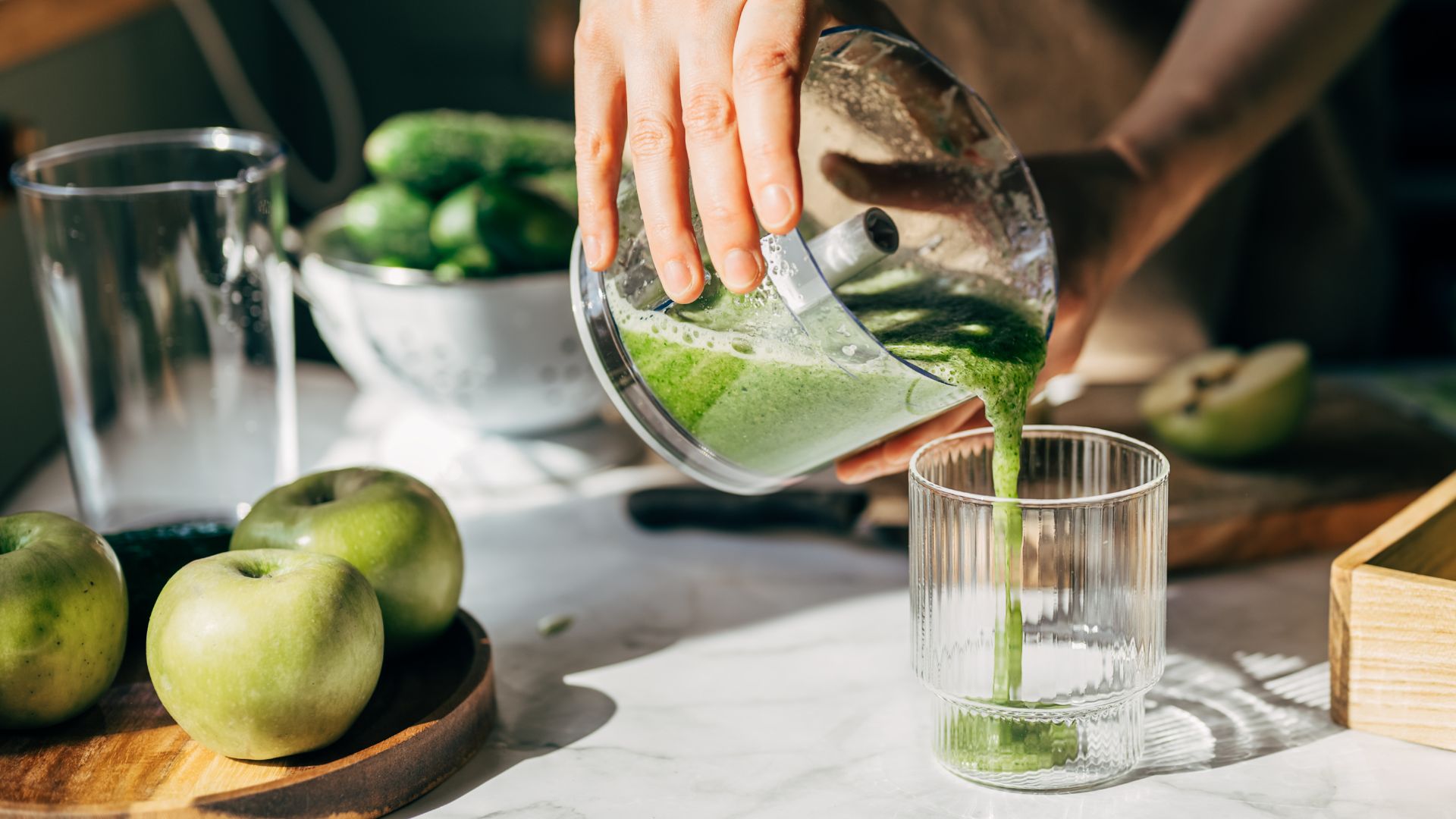 Green juice being poured into glass