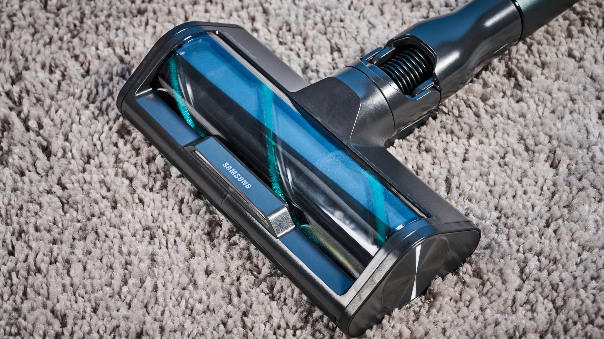 the samsung bespoke jet AI vacuum cleaner in mint green against a blue background, showing its ability to clean carpets and baseboards, as both a stick and a handheld