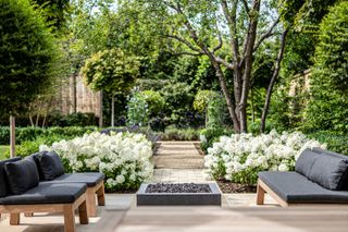 large garden ideas: patio area with brick and gravel pathway leading down the garden