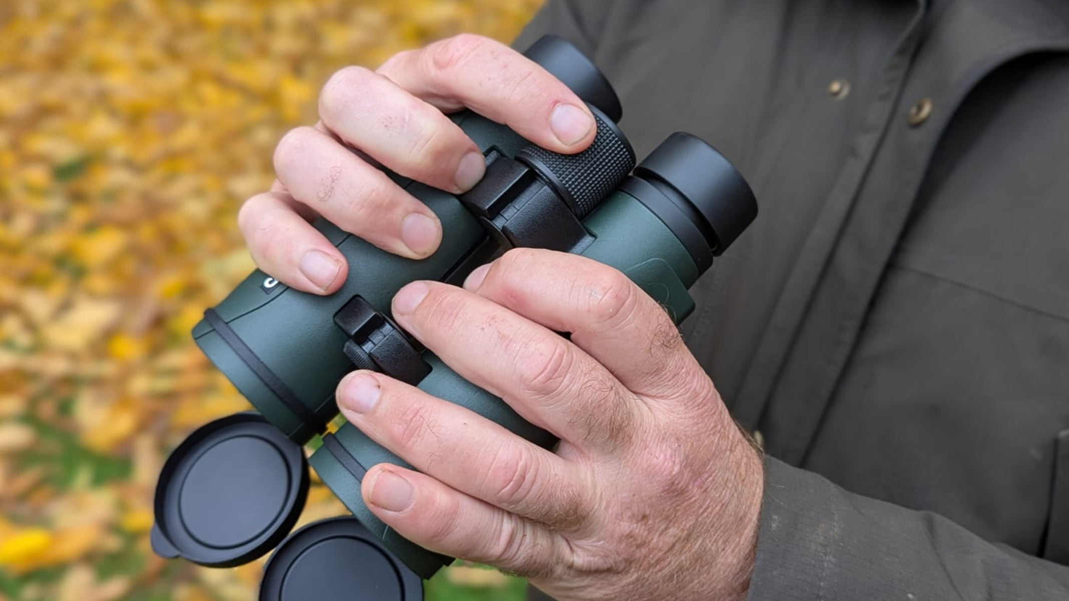 Our reviewer holding the Carson RD 10x50 binoculars, demonstrating the focusing wheel.