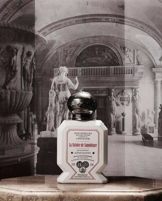 Buly 1803 white bottle of fragrance against black and white picture of Lourve galleries