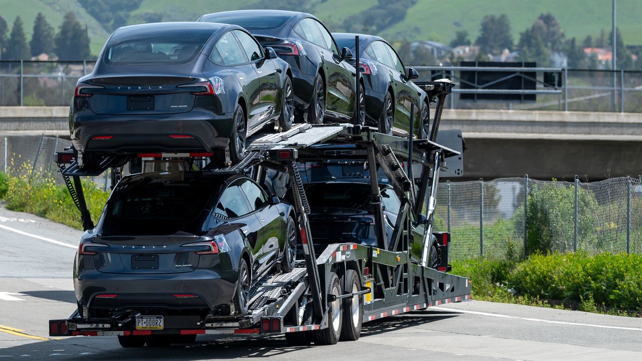 trailer hauling loads of black Teslas