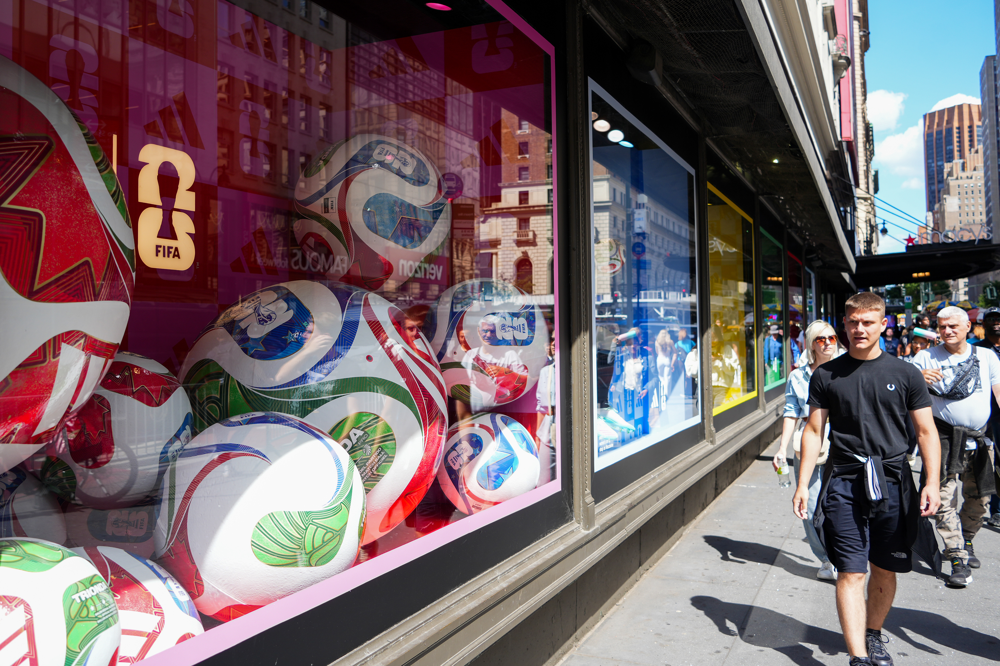 Giant footballs are displayed in a window at Macy