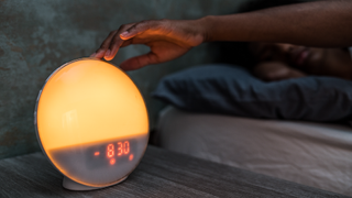 Woman turning off a sunrise alarm clock