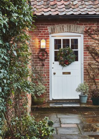 white door with wreath and light on in converted Victorian school building