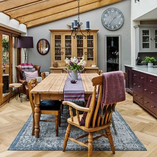 dining room with watch on wall and wooden dining table