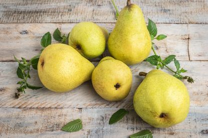 Five Whole Pears On A Wooden Surface