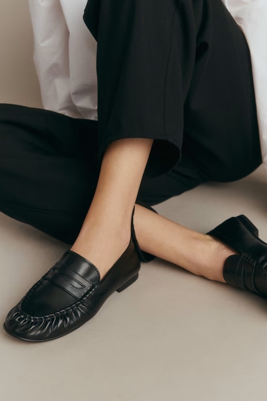 A model wearing black loafers.