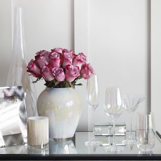 white room with flower vase and glasses