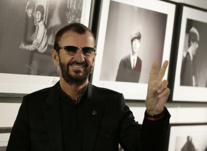 Ringo Starr poses in front of his photography show.