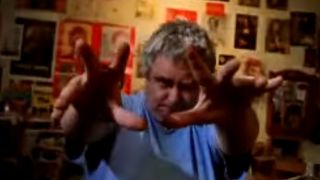 Daniel Johnston holding his hands up to the camera in The Devil And Daniel Johnston