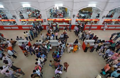 eople wait in lines to deposit and withdraw money inside a post office in Lucknow, India.