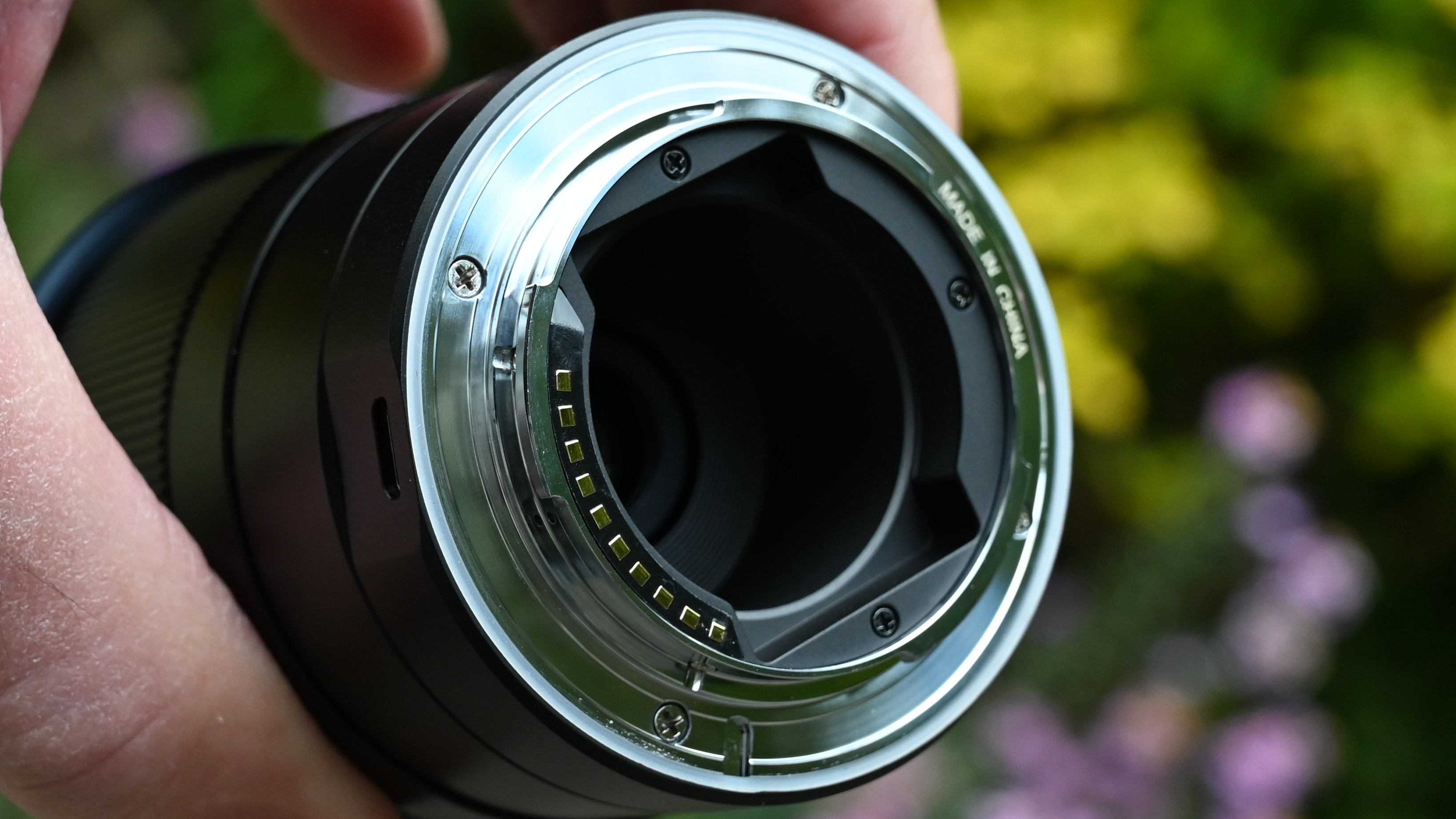 Laowa 15mm f/4.5 0.5x Macro product shot with lens held in hand