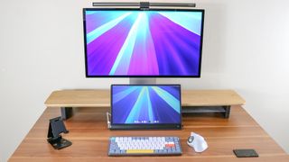 A desk setup built around Apple&#039;s Studio Display and Mac mini M4 with the premium monitor raised up on a desk shelf