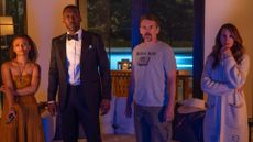 Ruth, G.H, Clay, and Amanda stare at a TV screen in Leave the World Behind, one of the new Netflix movies